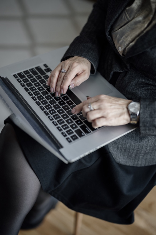 Mains sur un ordinateur portable, tenue professionnelle
